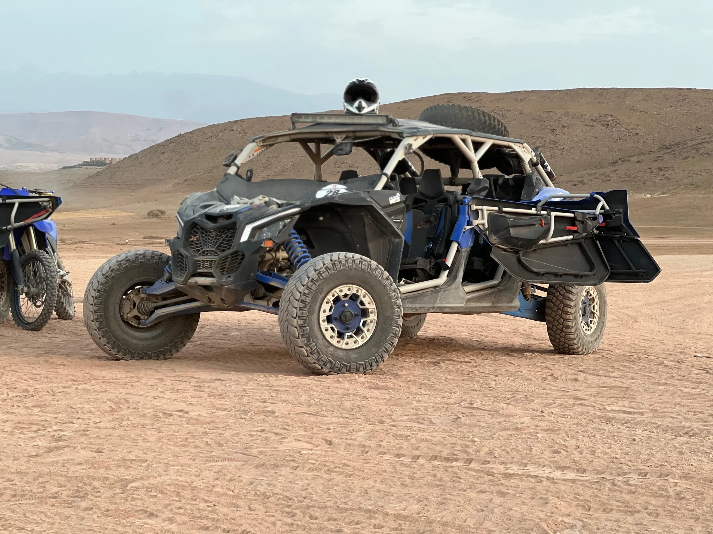 An off-road buggy driving away, raising dust in the desert