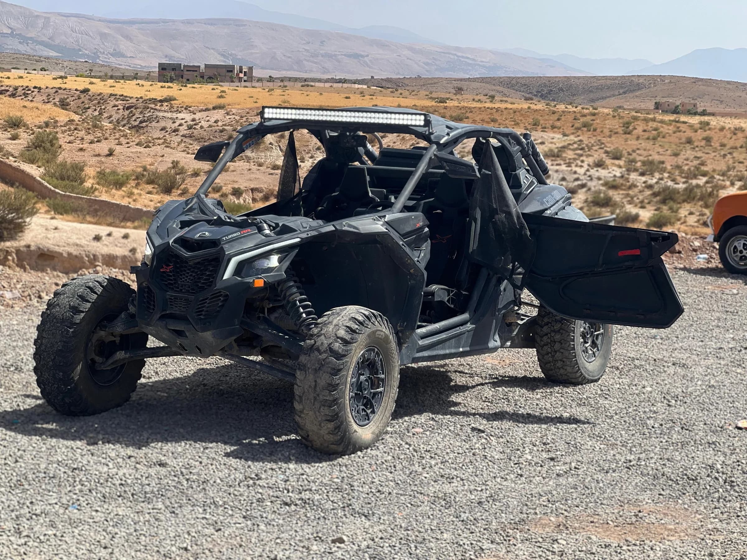 An off-road buggy parked beside a desert road