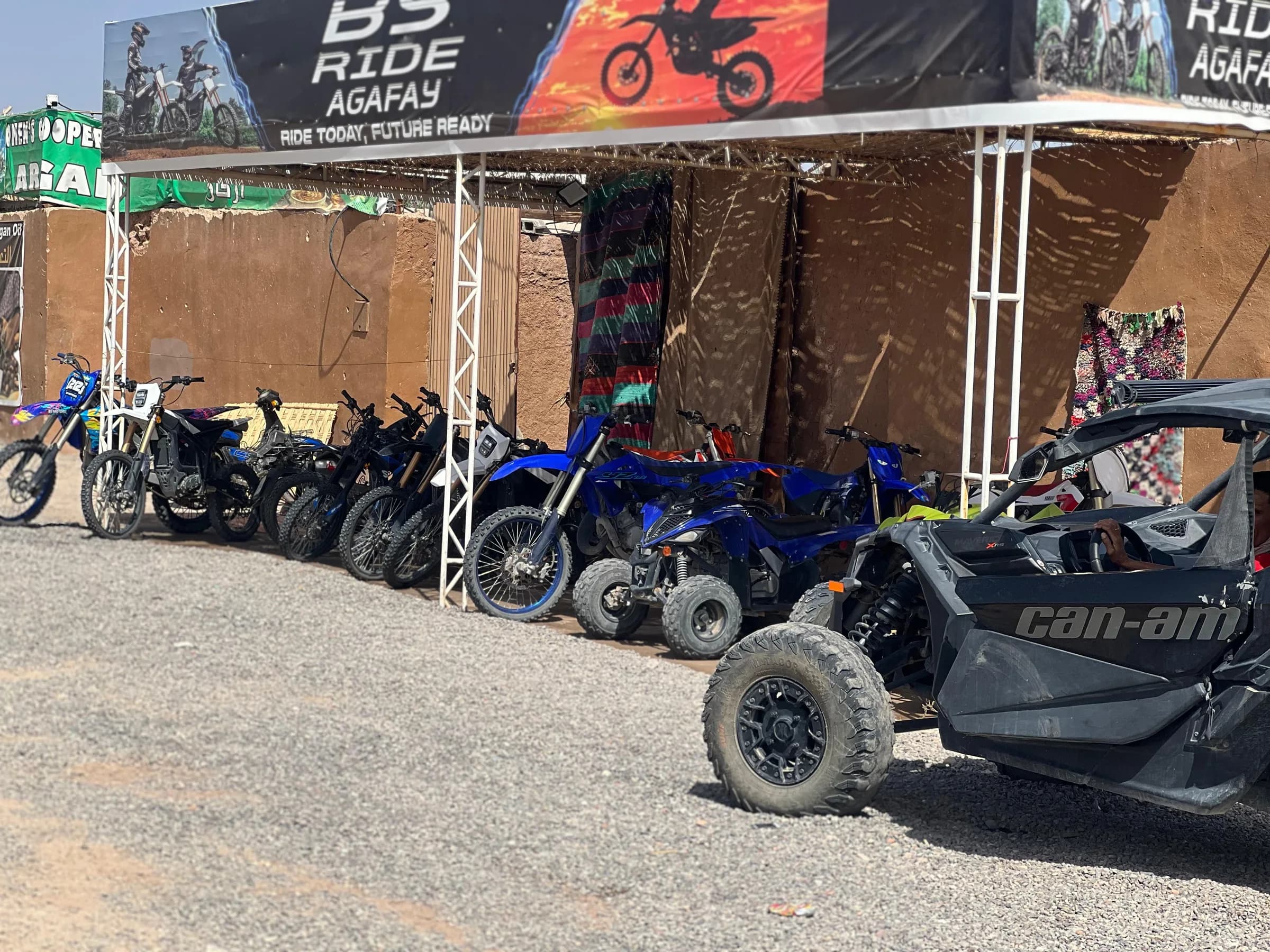 A group of motorcycles and a buggy parked at the rental shop