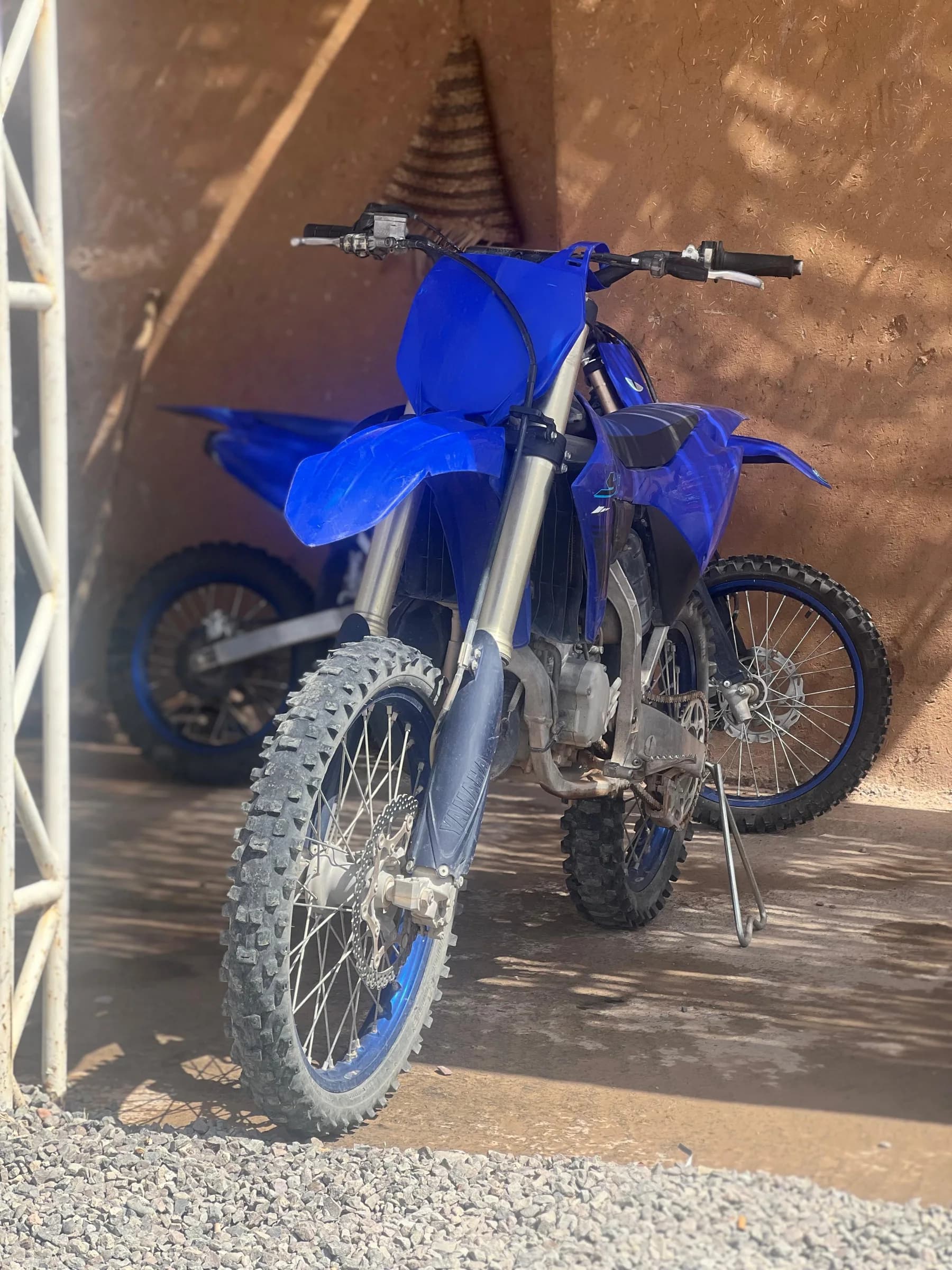 A blue dirt bike parked against the rental shop wall