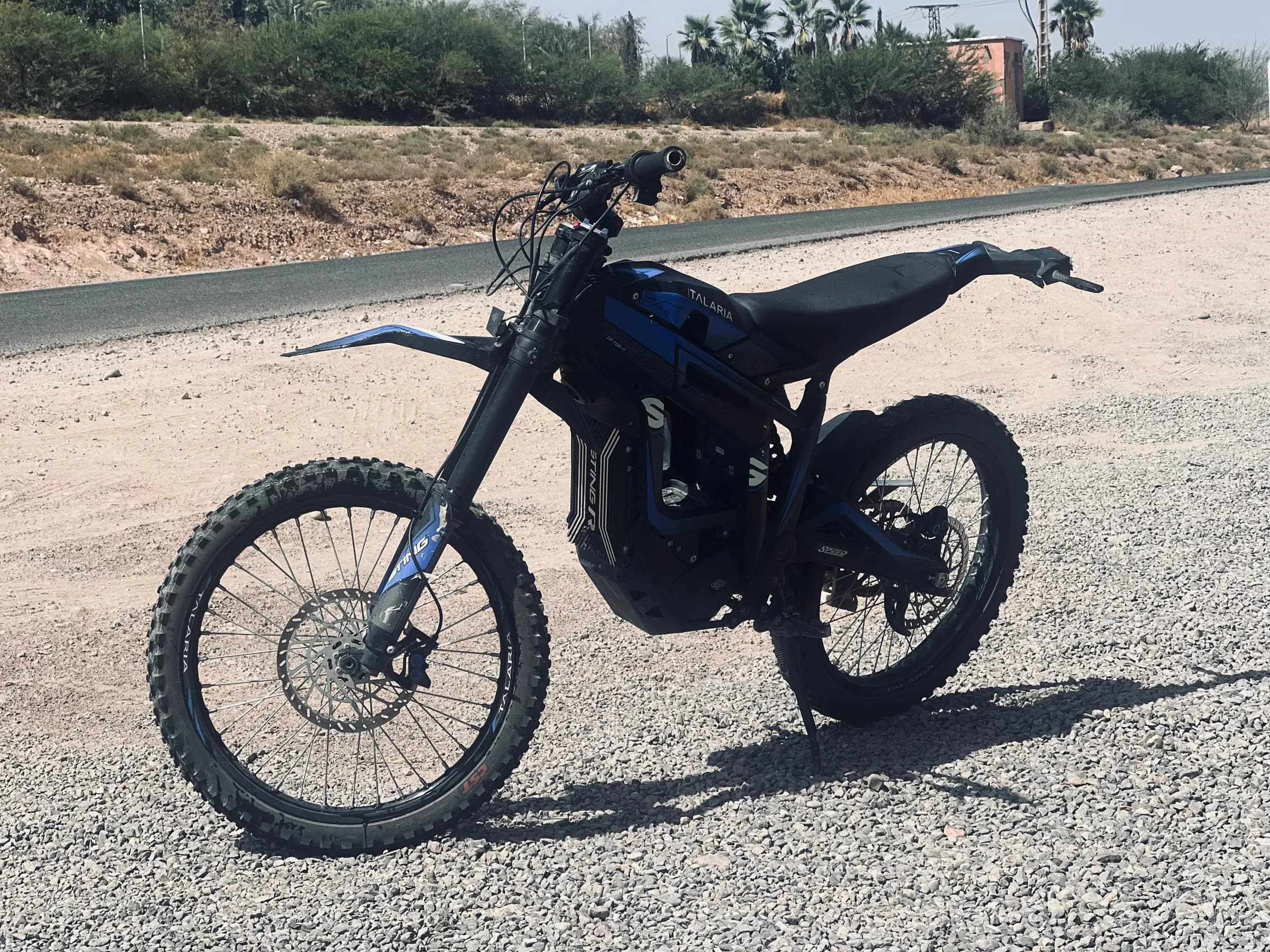 A black electric dirt bike parked beside a road