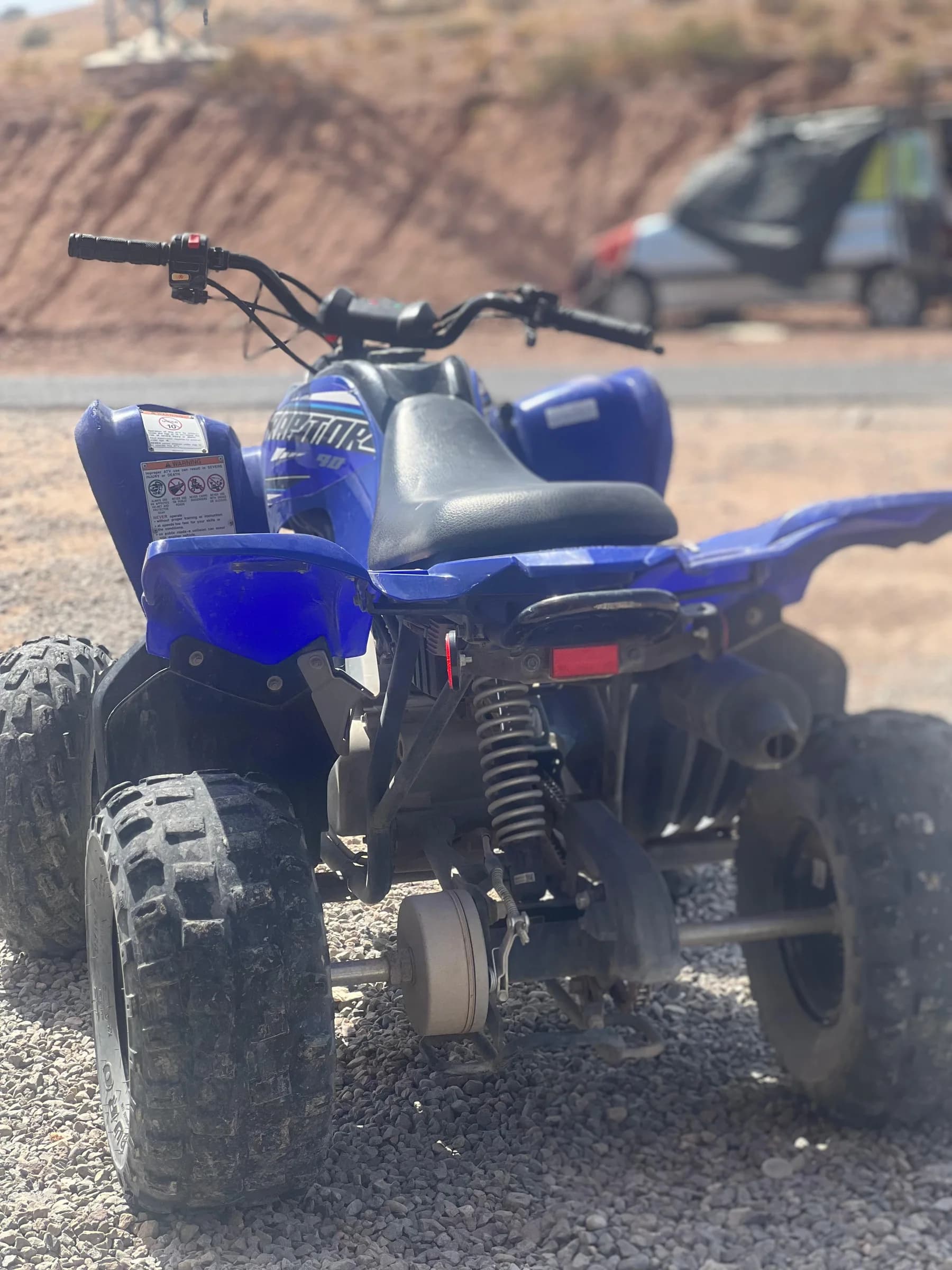 A blue quad bike parked at the rental shop