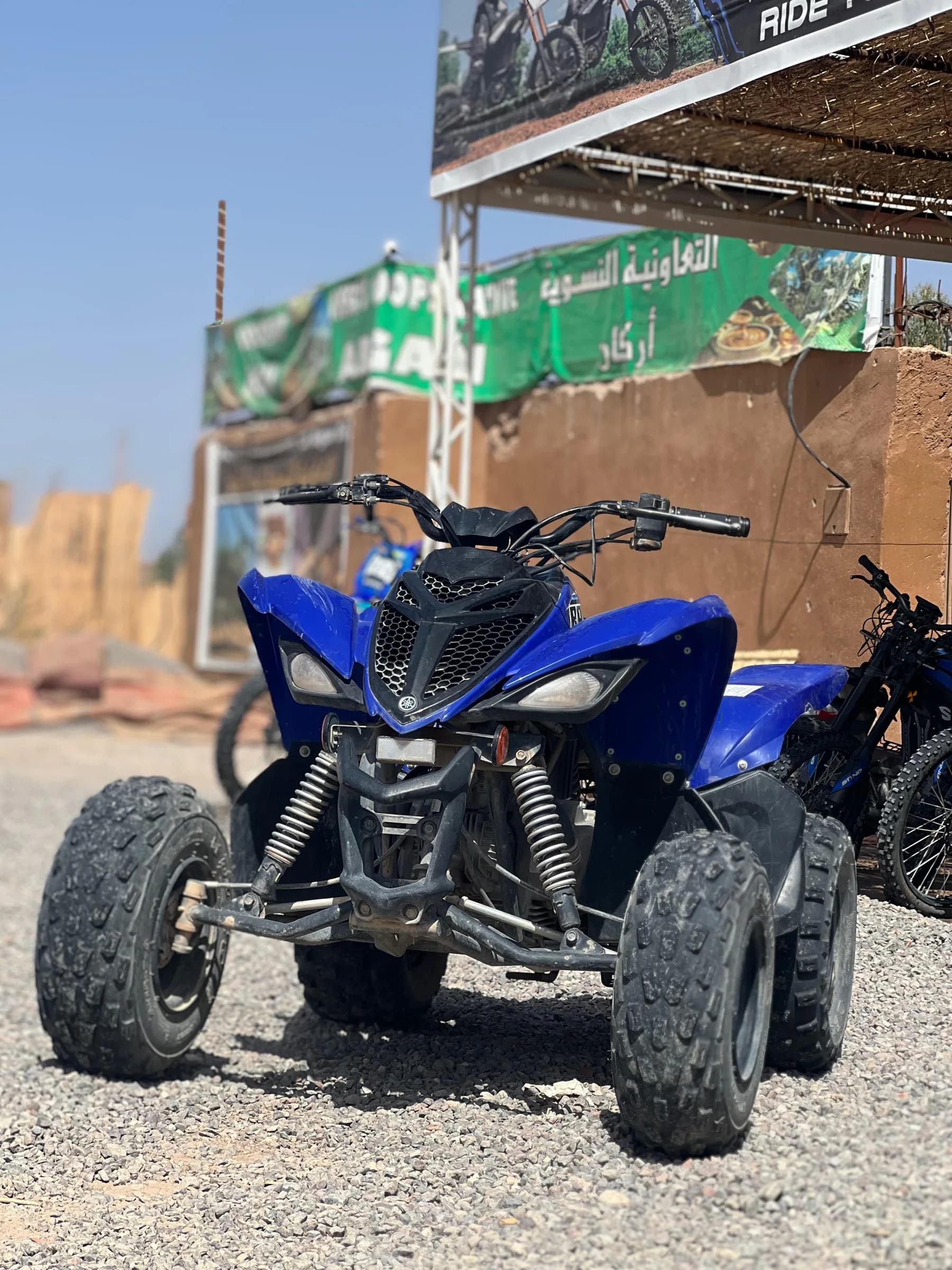 A blue quad bike parked in front of the rental shop