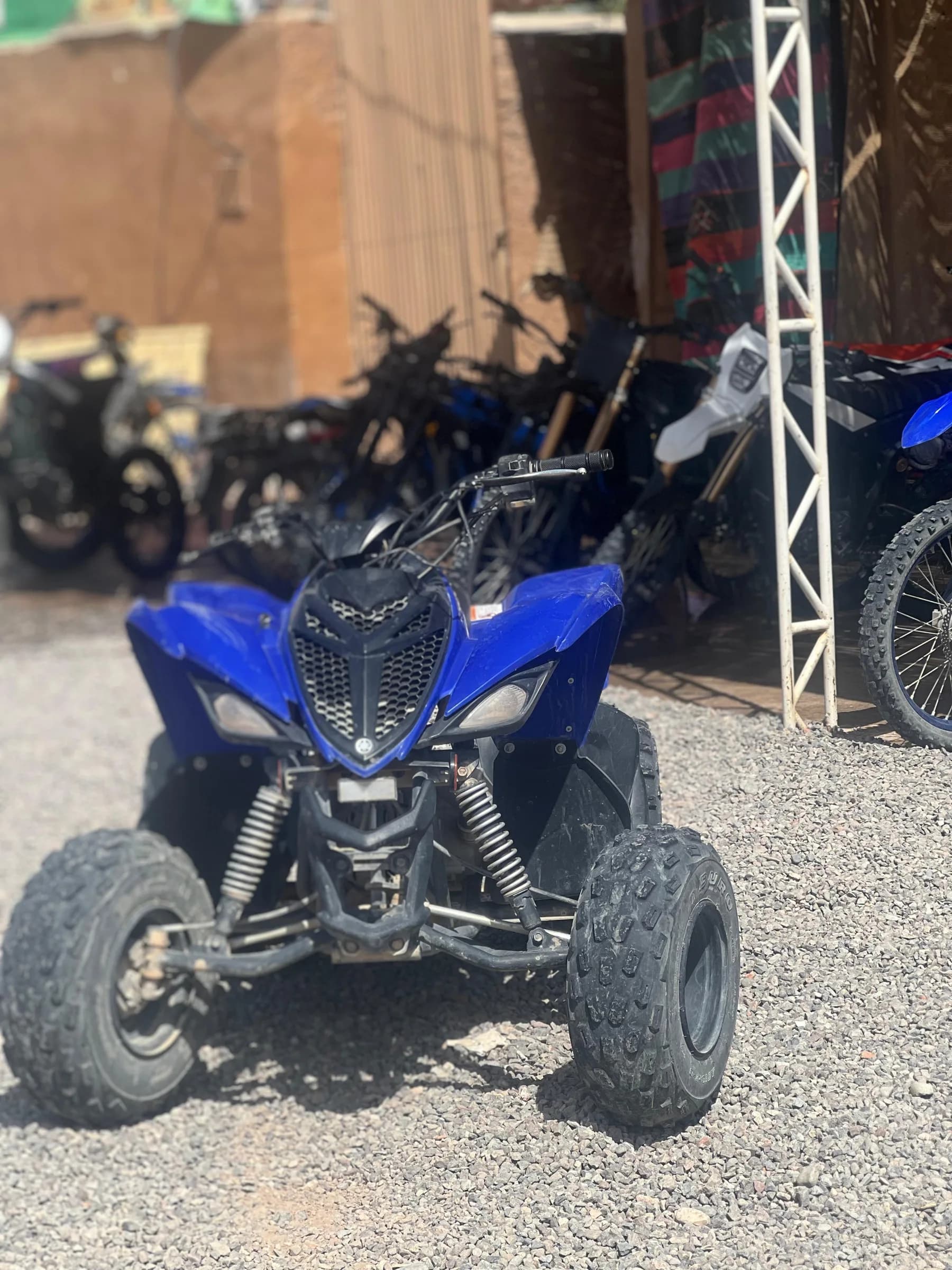 Side view of a blue quad bike parked outdoors