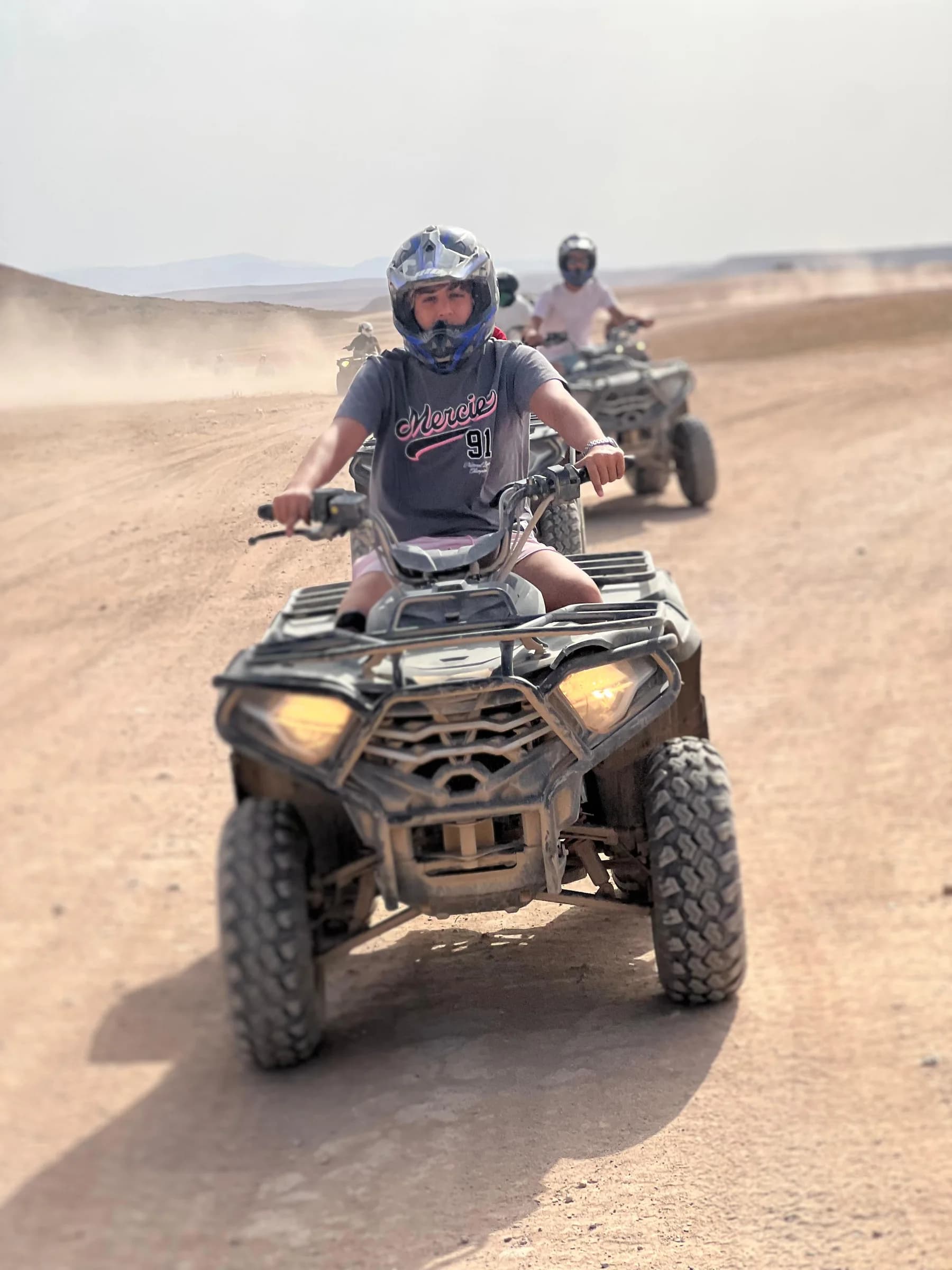 A rider on a quad bike riding along a desert trail
