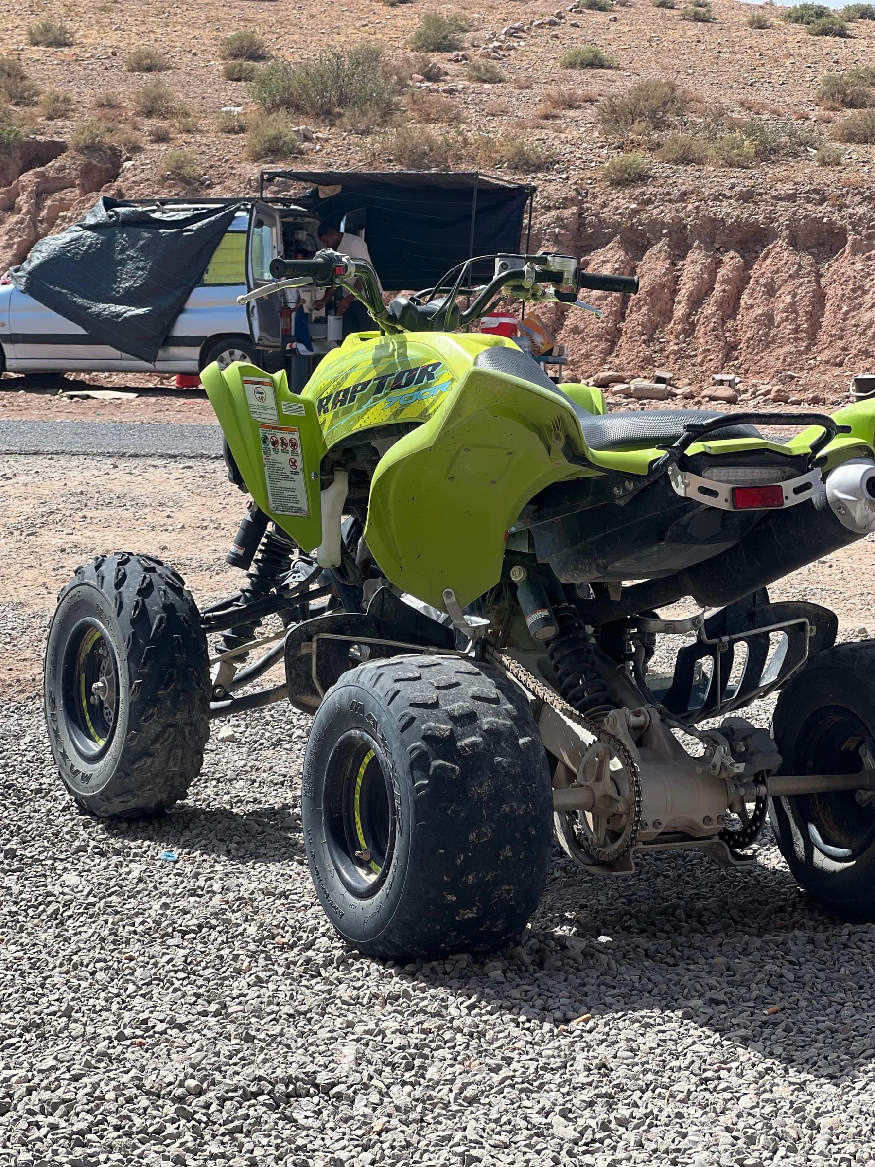 Rear view of a lime green quad bike parked outdoors