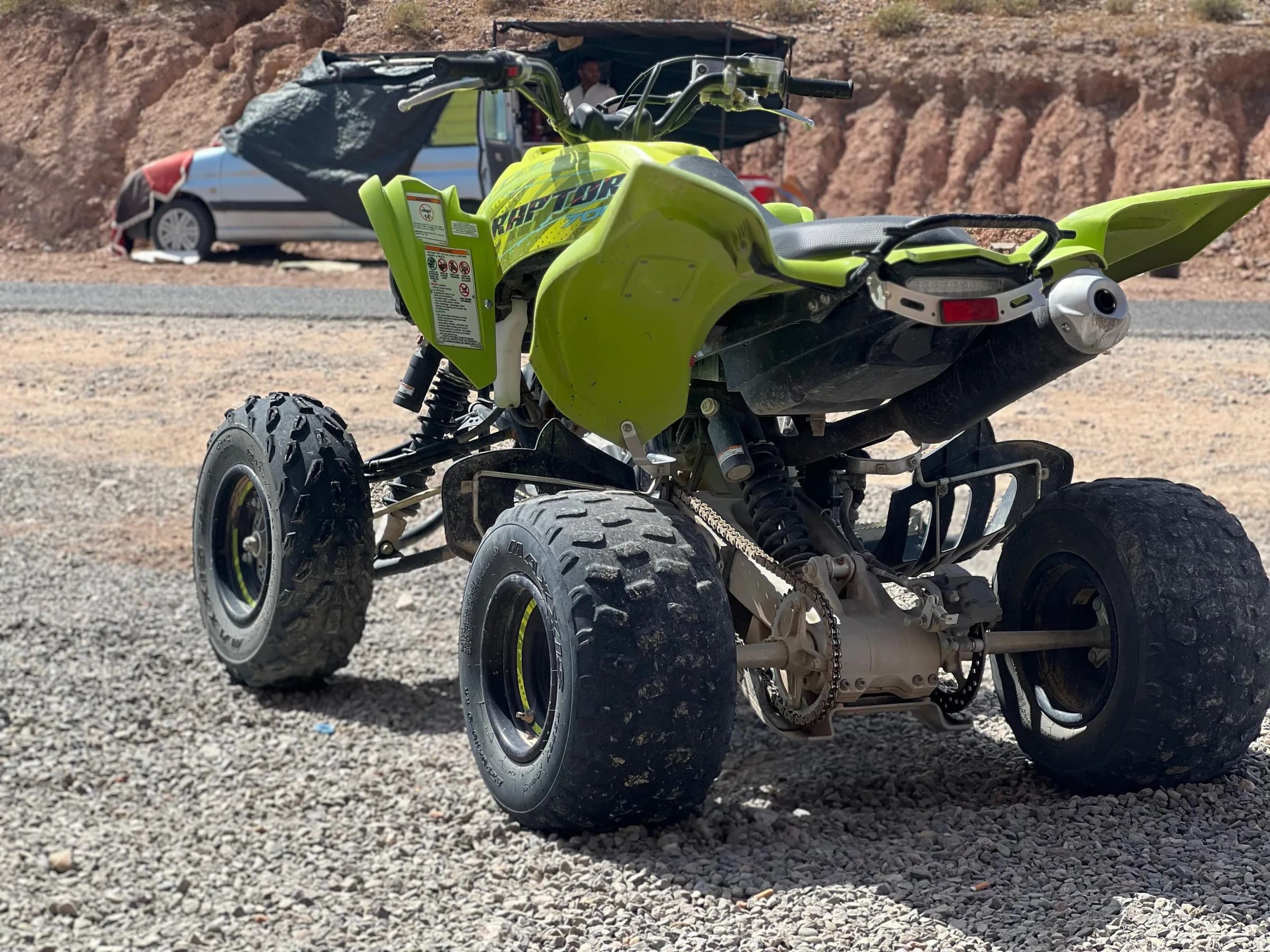 Side view of a lime green quad bike parked outdoors